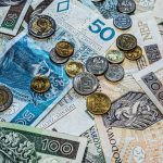 Close-up of Polish złoty currency, including various banknotes and coins scattered.